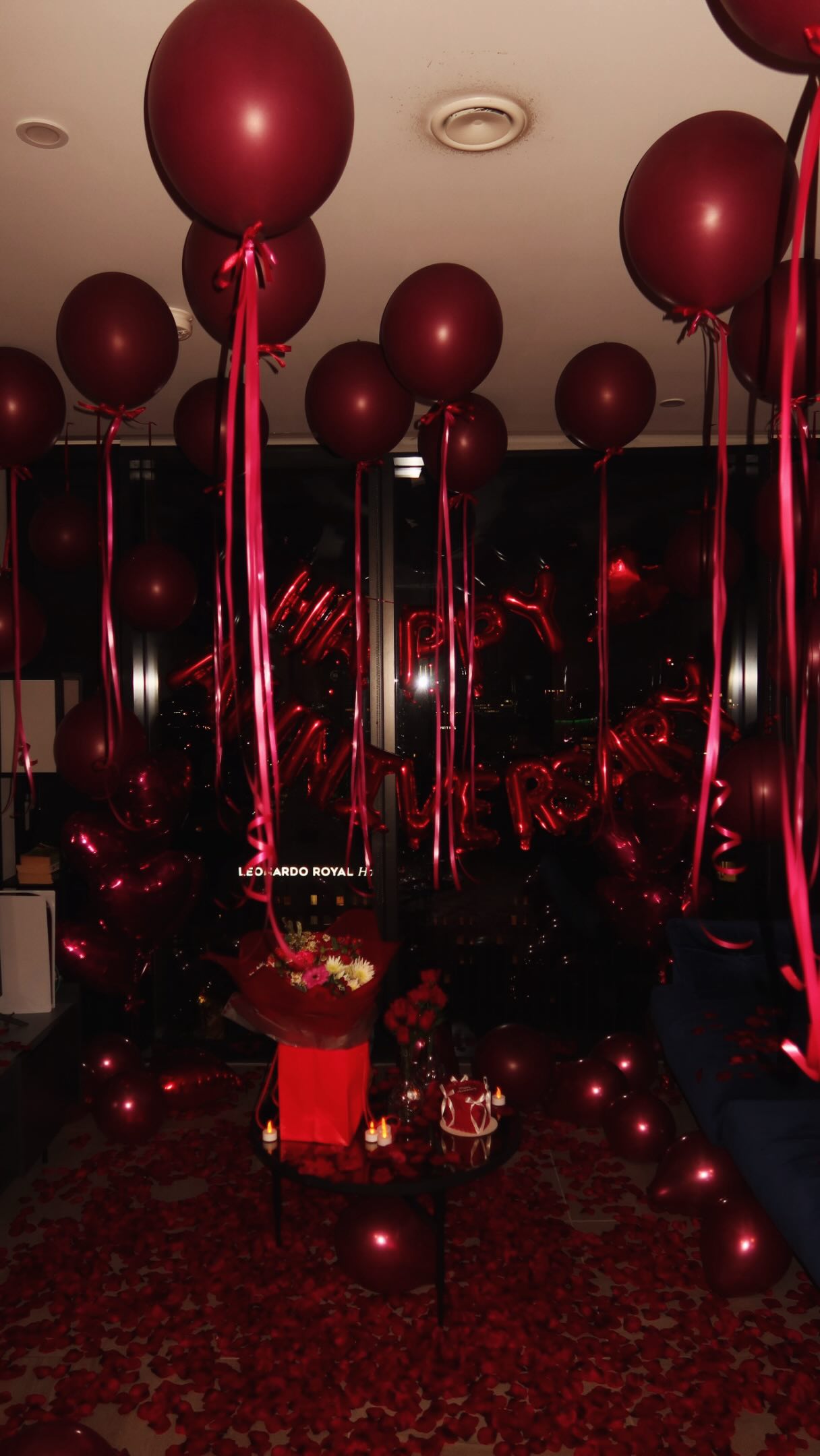 Deep red romantic anniversary styling with roses and petals